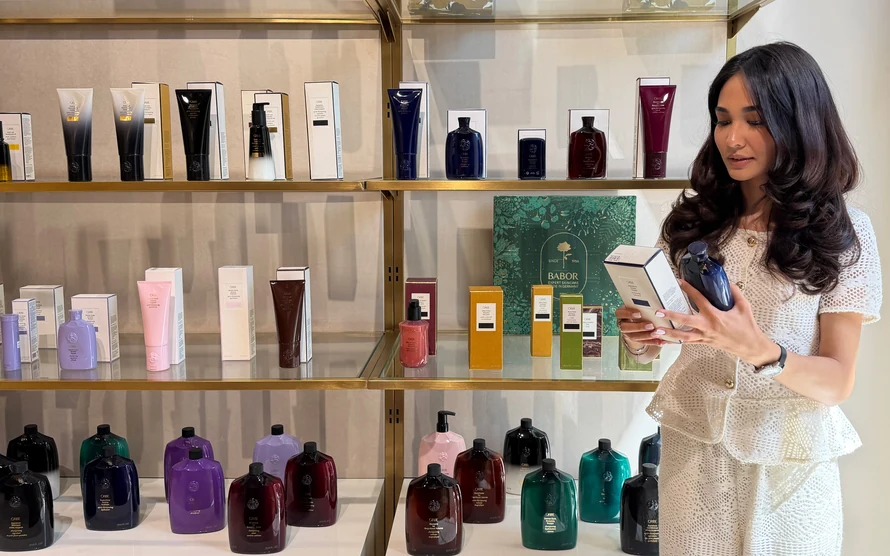 Сотрудница Shine Bright у витрины Oribe